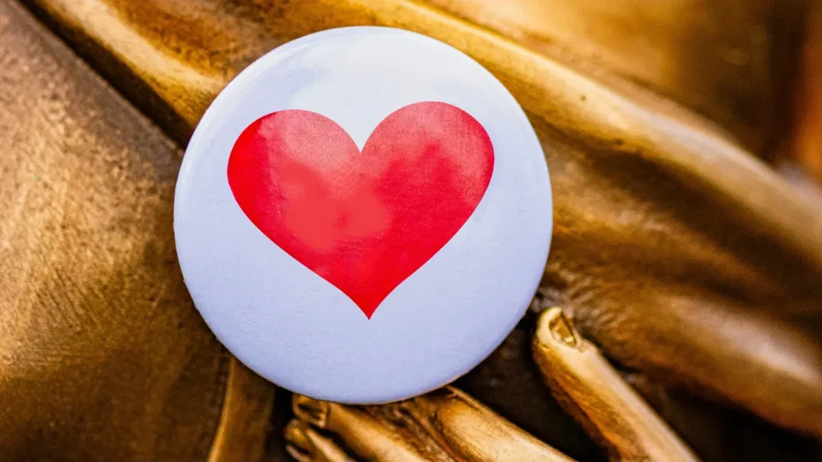 Heart button on gold statue hand