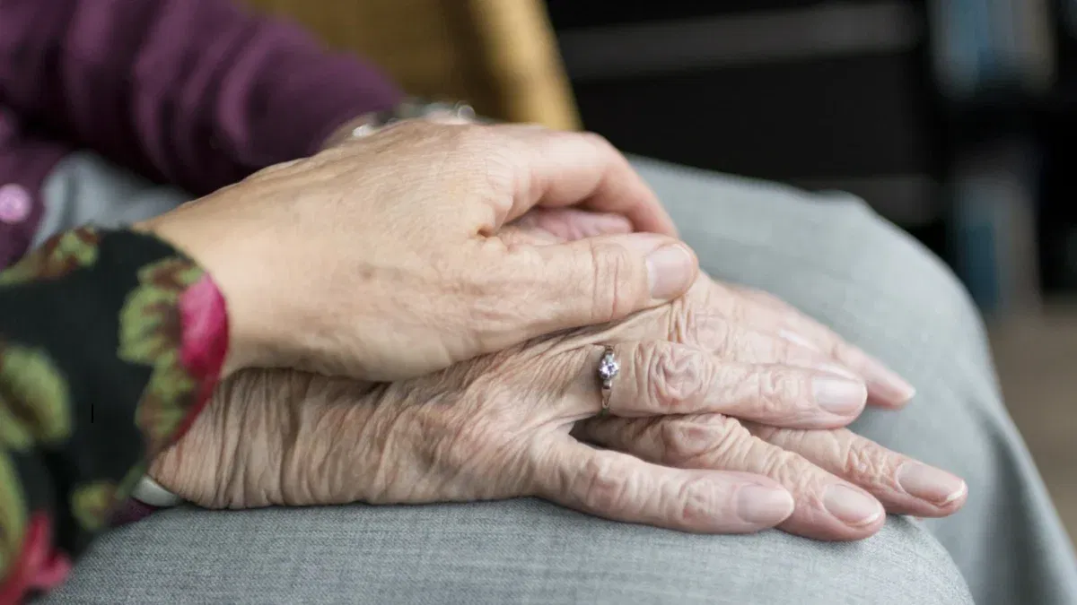 Elderly hands with a ring, showing comfort and care.
