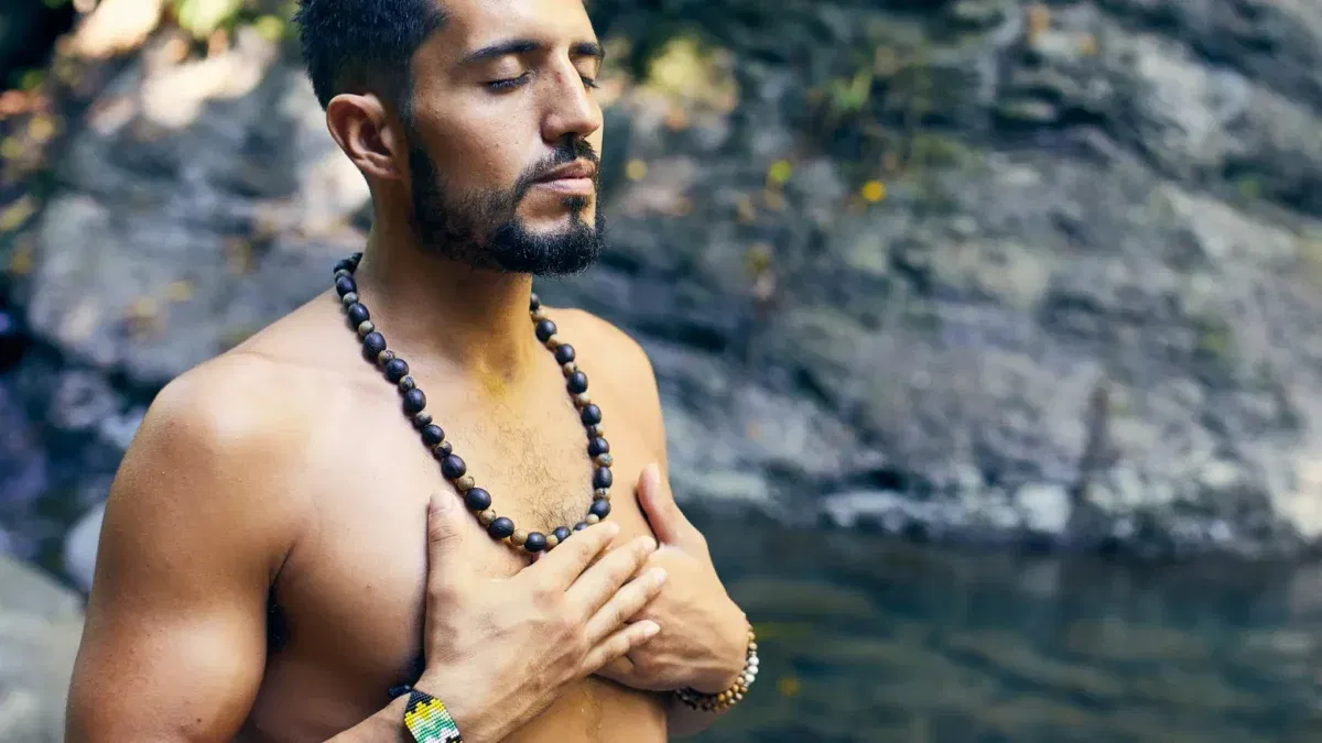 Man meditating by a peaceful river.