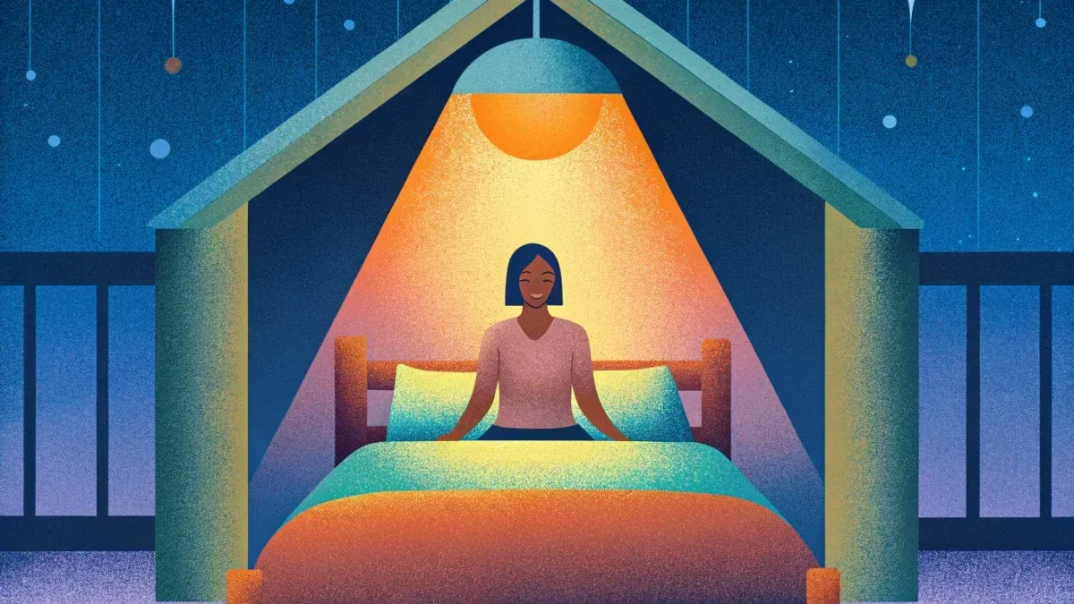 Person sitting on bed under stars, warm glow.